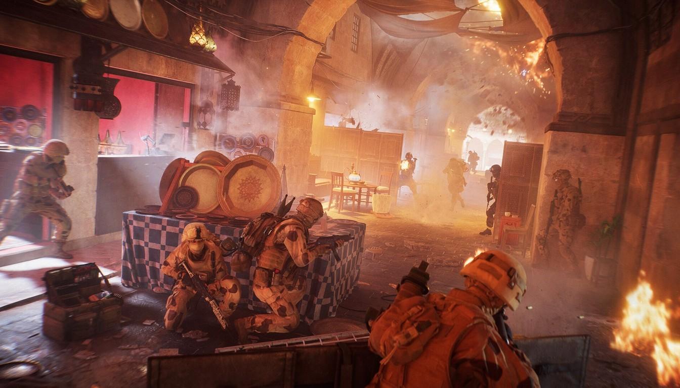 Soldiers taking cover among carpets and dishes in a burning Middle Eastern bazaar