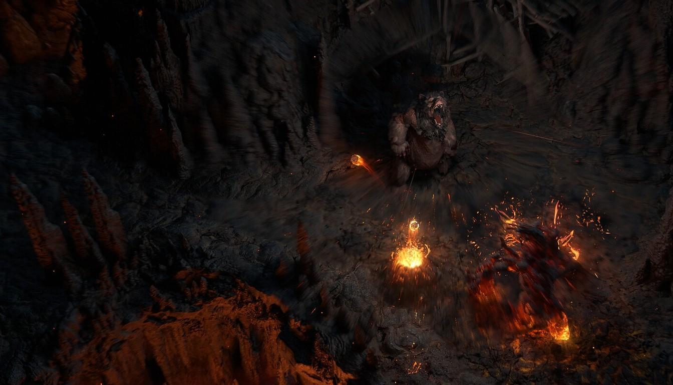 A lone figure beside a campfire in a dark volcanic cave