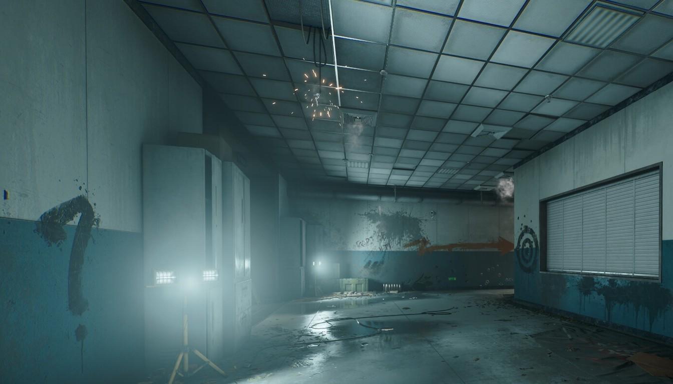 Dark concrete plant corridor with fog, puddles on the floor and a work light