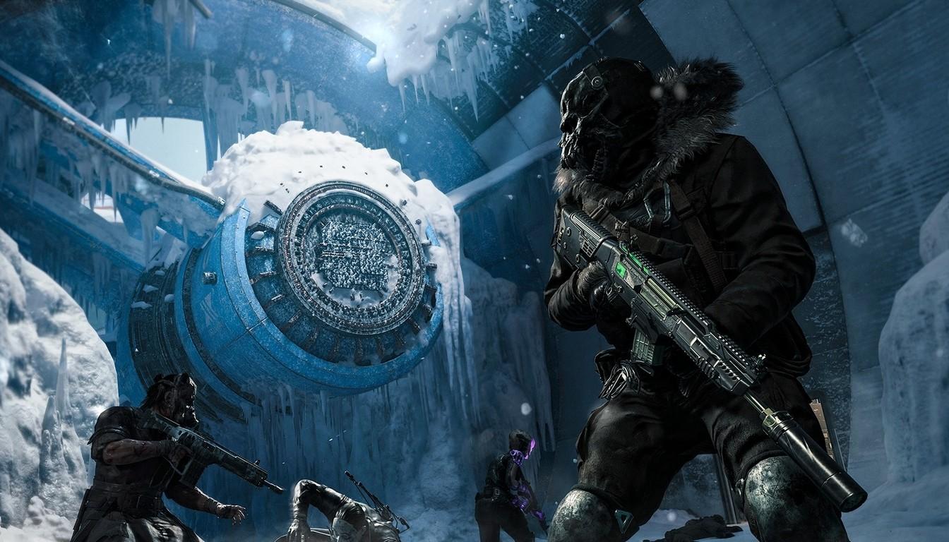 Two operators in winter gear beside a round mechanism in the ice