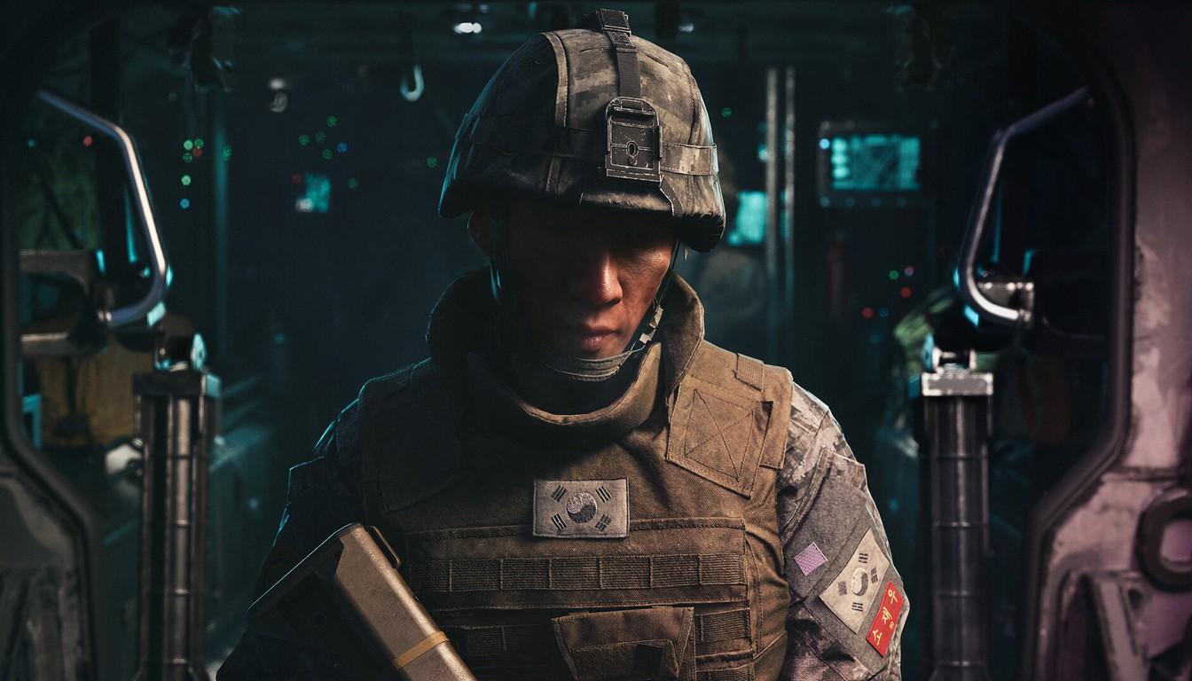 A helmeted soldier in body armor inside a dark vehicle compartment
