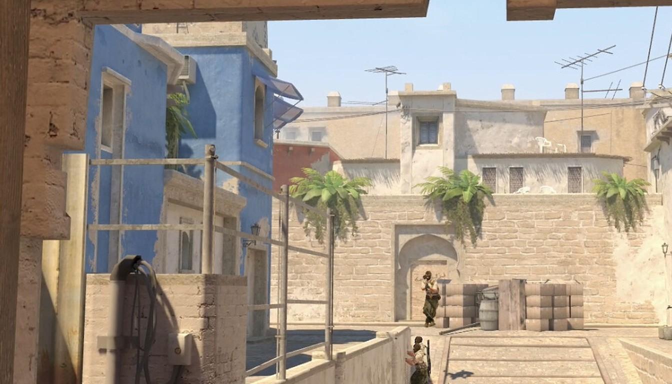 A narrow lane between buildings on a desert map with players holding positions