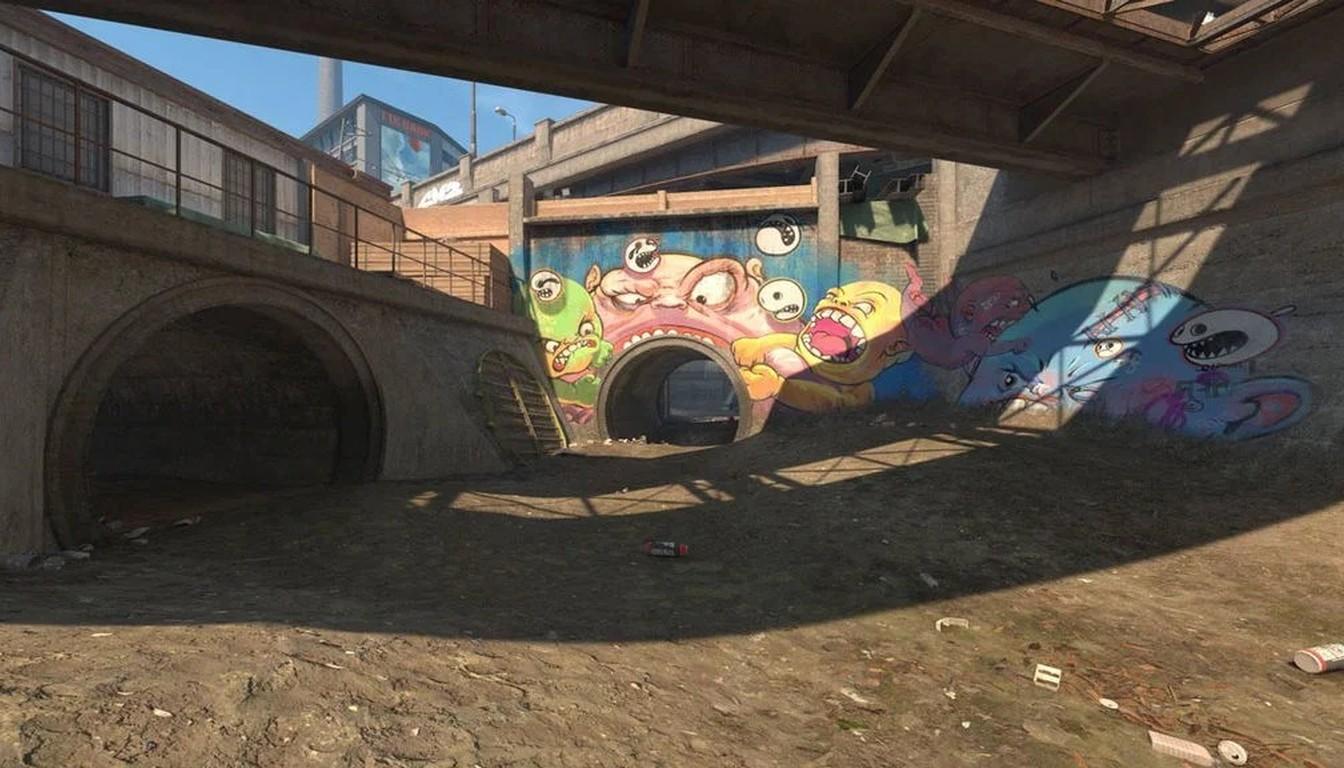 Open passage under a bridge with graffiti and dark archways