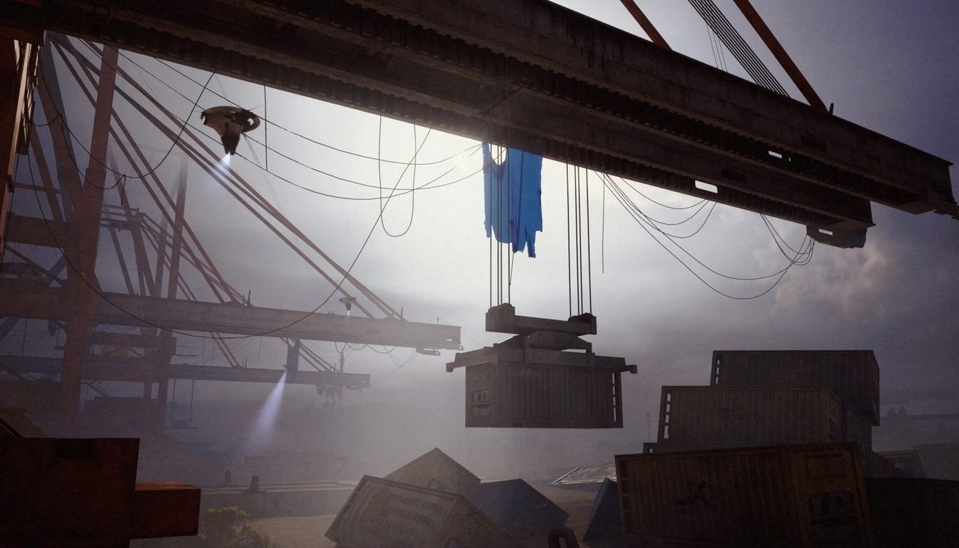 A harbor crane lifting a container above stacked containers